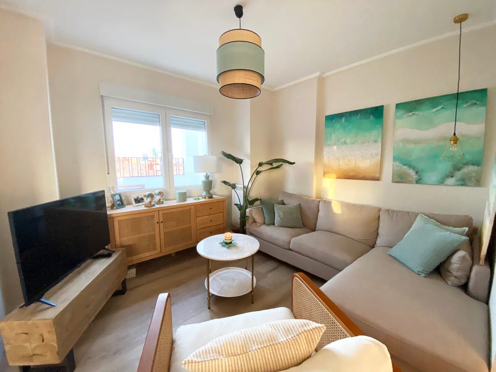 salón con sofá con chaise longue gris y cuadros inspirados en el mar