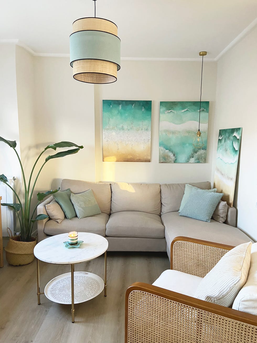 salón con sofá con chaise longue gris y cuadros inspirados en el mar