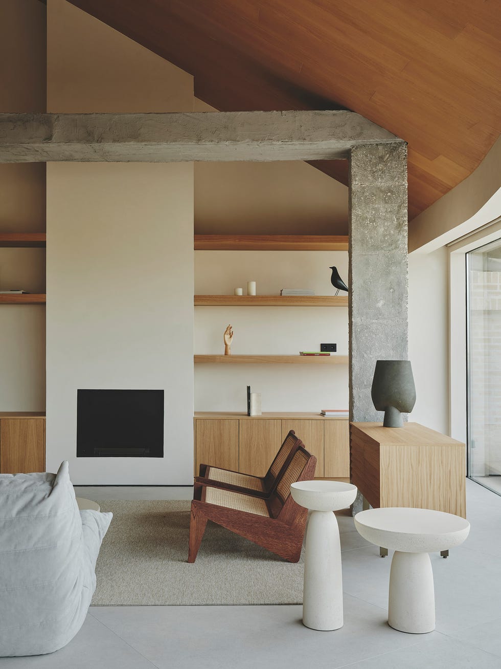 salón abuhardillado con chimenea y estantería de madera