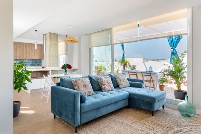 salón comedor abierto a la cocina y a la terraza y decorado en azul