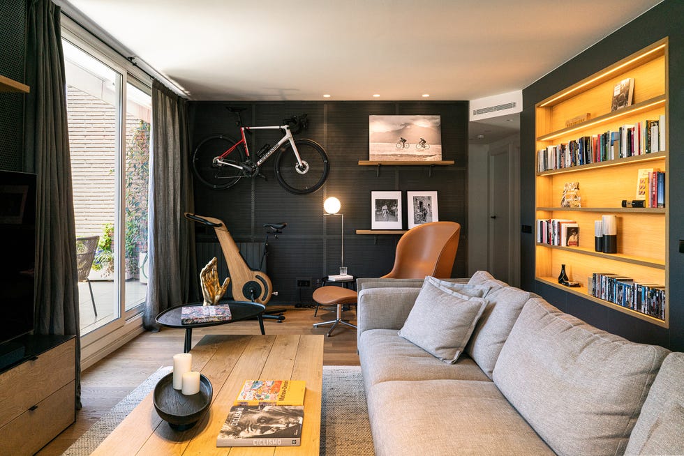 salón industrial con sofá gris y zona de lectura