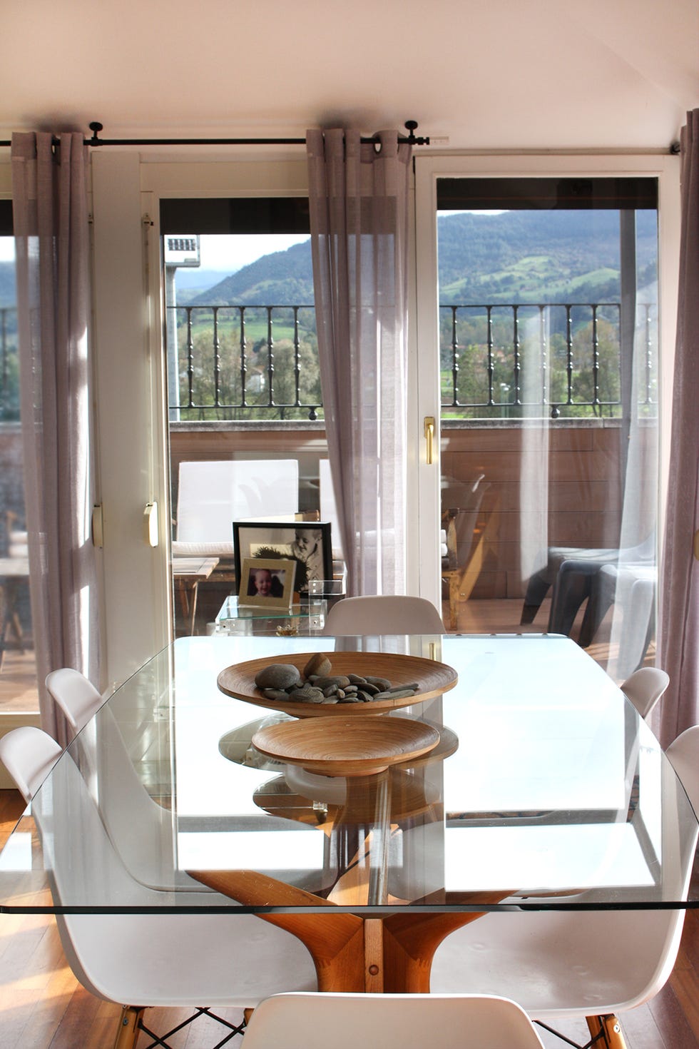 comedor de estilo nórdico con mesa con sobre de cristal