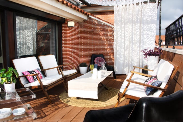 terraza con butacas de madera y alfombra de fibras
