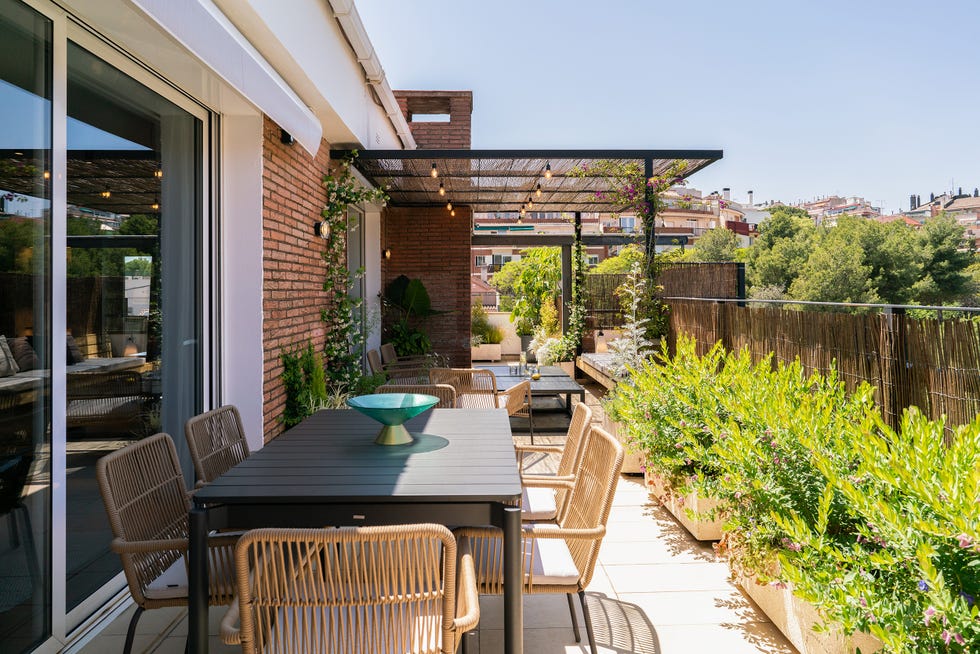 terraza con comedor exterior y zona de asientos bajo una pérgola
