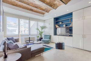 salón moderno con sofá con chaise longue y techo de bóveda catalana