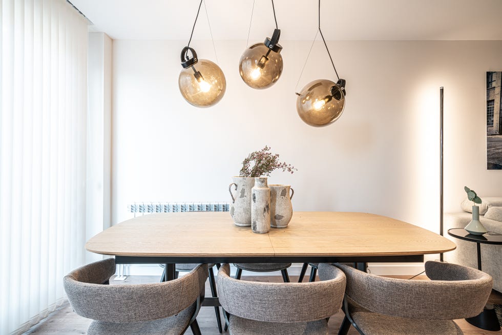 comedor con mesa de madera y sillas tapizadas con tela gris