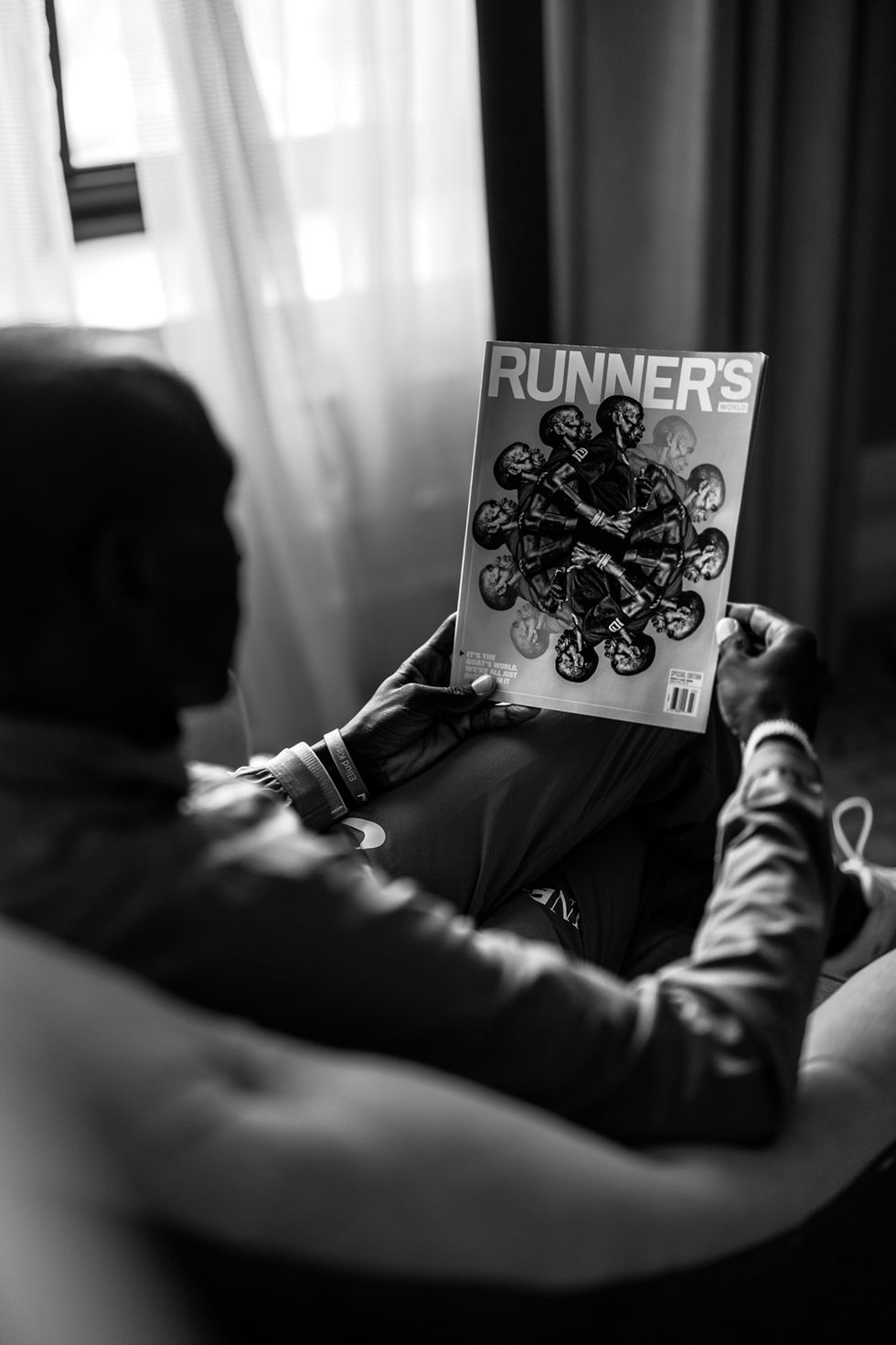 eulid kipchoge reads the newest issue of runners world featuring him on the cover