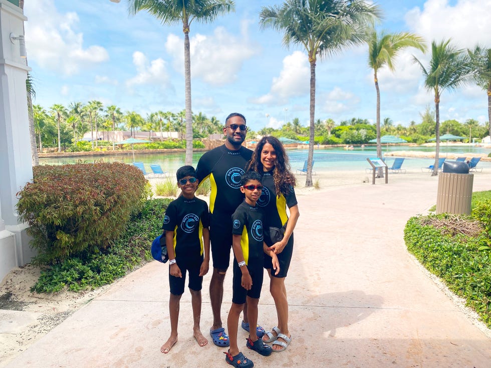 family standing together at a resort near a lagoon