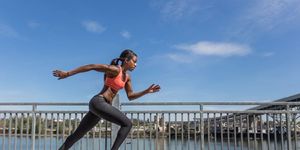 Attractive ethnic female sprinter training in the city