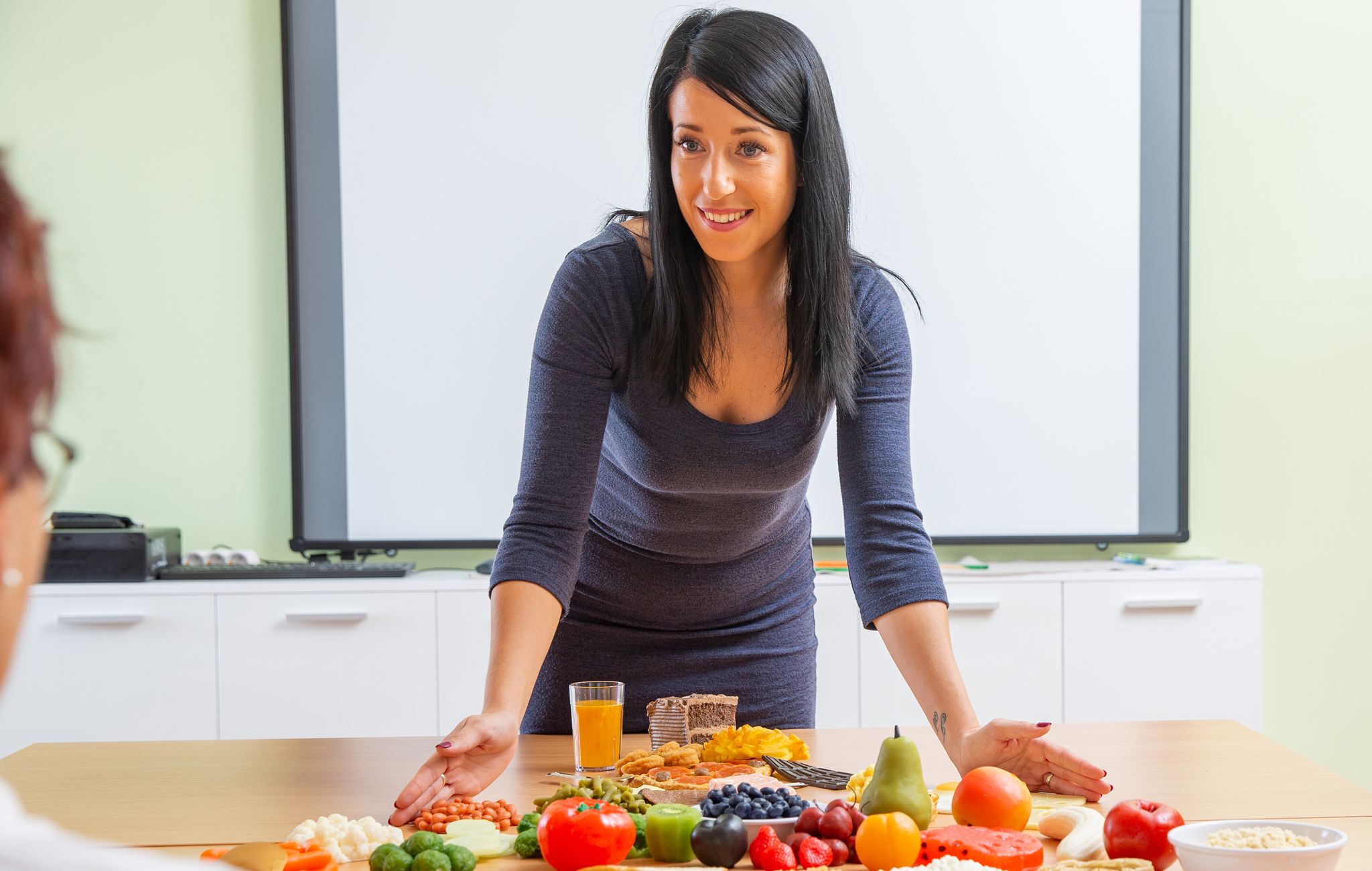 attractive female doctor presenting about healthy eating using food pyramid   stock photo