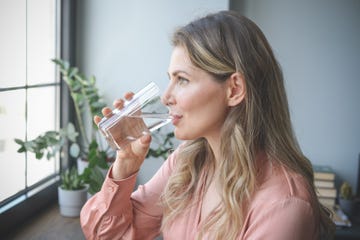 attractive middle aged woman in the office  drinking water