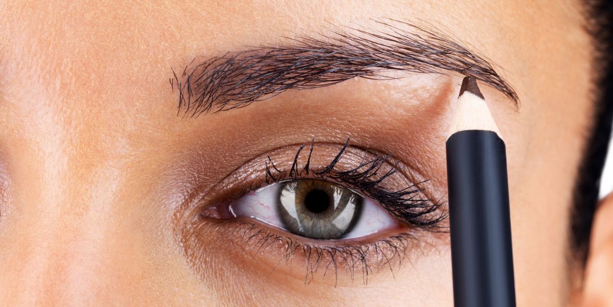 attractive woman applying eyebrow pencil