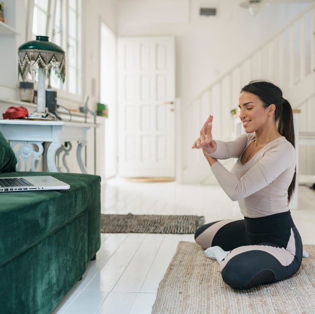 attractive young woman showing warm up exercises online