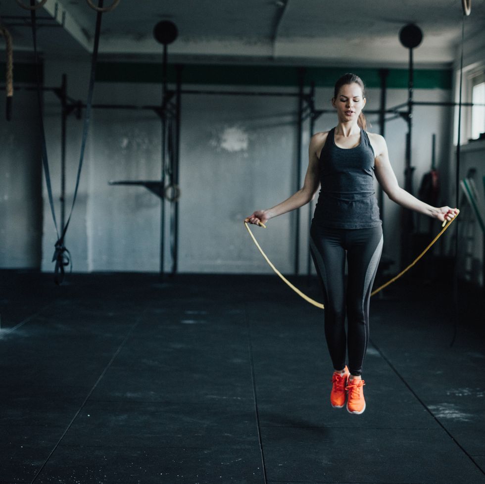 Attractive young woman uses jumping rope to train