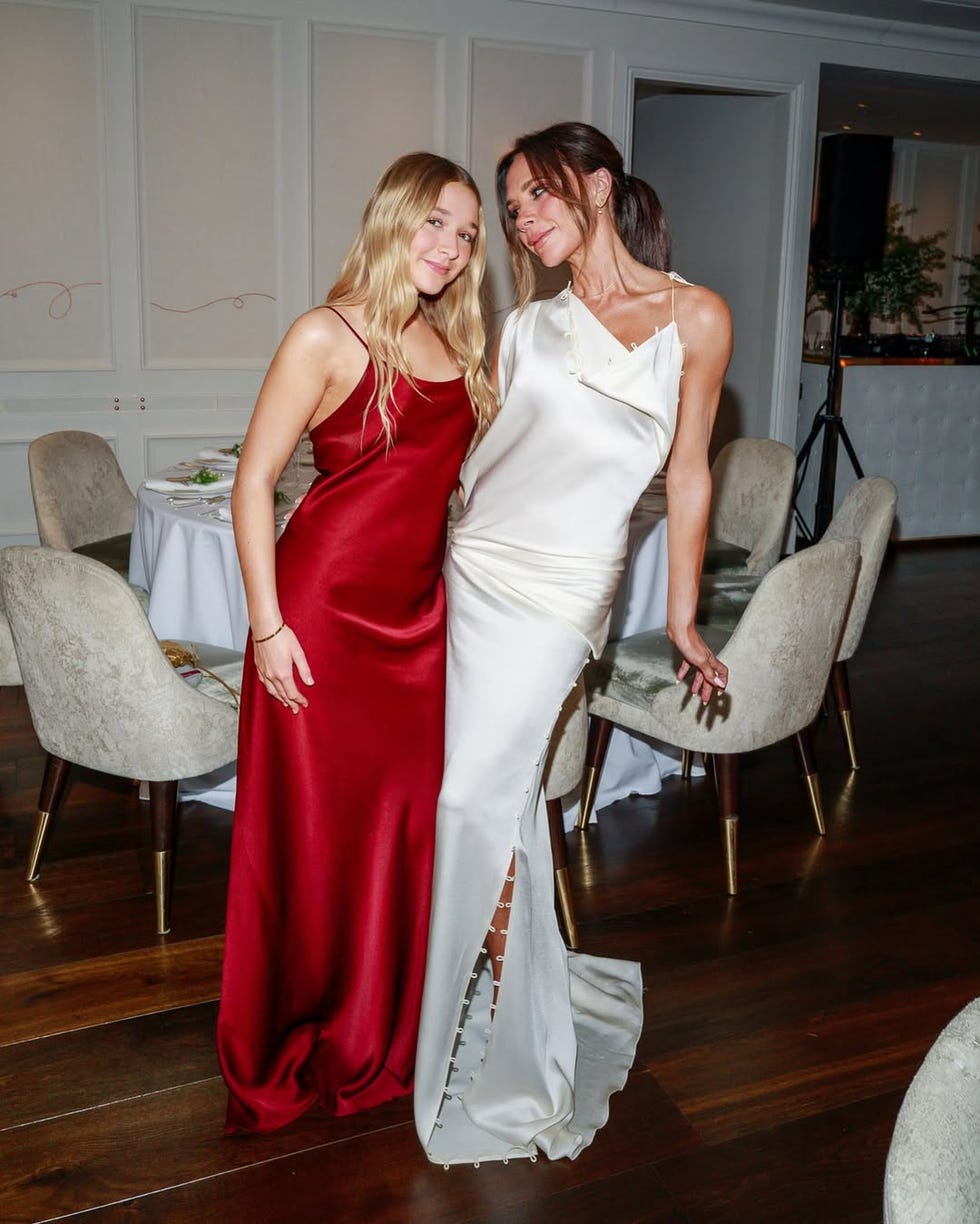 two women in formal dresses posing together at an event
