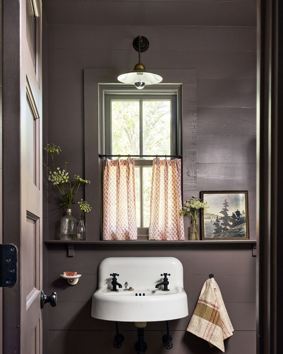 aubergine powder bathroom with a salvaged white wall mount sink