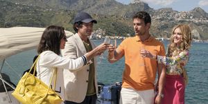 four people toasting with champagne on a boat in italy