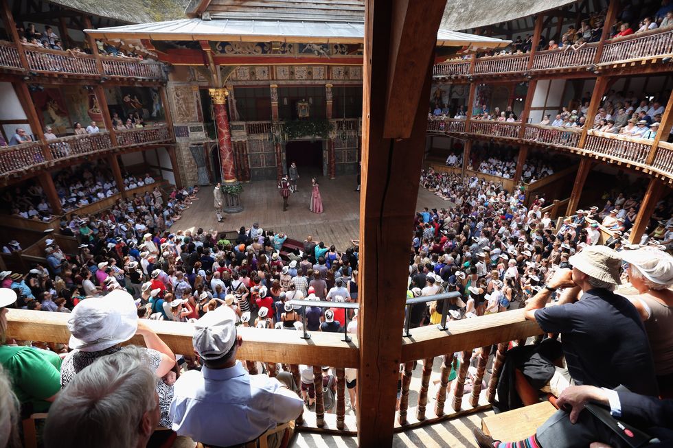 theatregoers enjoy the sunshine during a performance at the globe