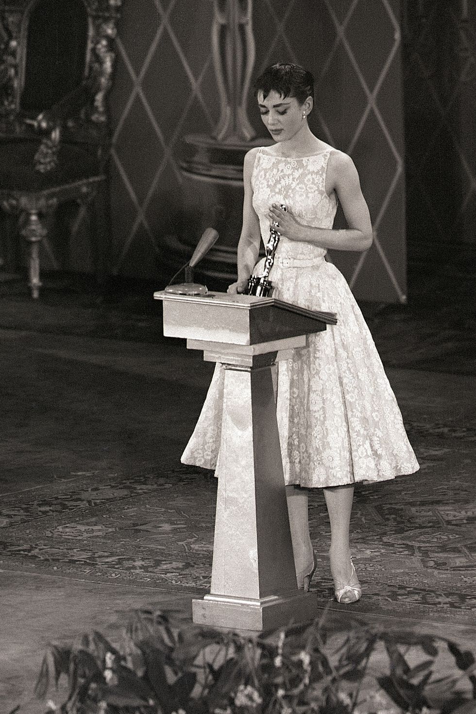 original caption 3251954 new york  audrey hepburn smiles sweetly as she receives hollywood's highest accolade  an oscar for the best performance by an actress  from jean hersholt at the center theater tonight the 22 year old stage and screen star won her award for her only american film, "roman holiday"