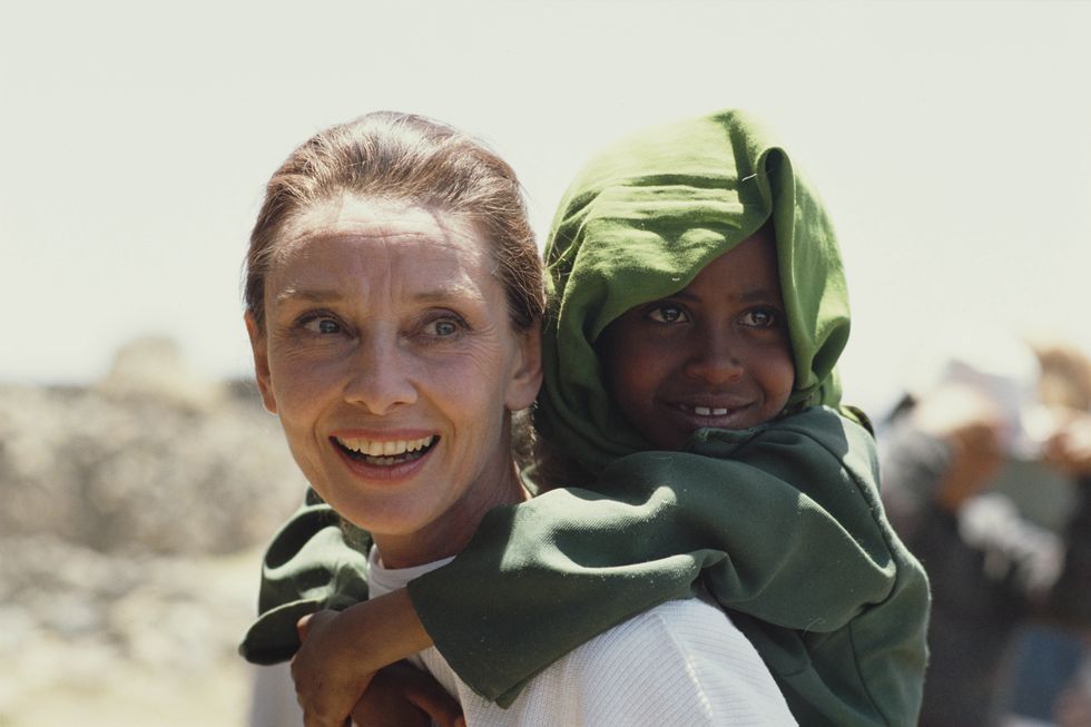 british actress and humanitarian audrey hepburn 1929   1993 carrying an ethiopian girl on her back while on her first field mission for unicef in ethiopia, 16th 17th march 1988 photo by derek hudsongetty images