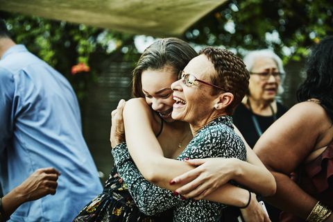 Aunt embracing niece after outdoor family dinner party