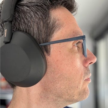 auriculares inalámbricos un hombre con unos auriculares sony sony wh 1000xm5 en la cabeza mientras una mano sujeta unos auriculares bowers & wilkins px7 s2e