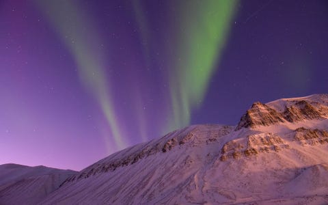 Longyearbyen op het Noorse Spitsbergen de enige plek op aarde waar je het noorderlicht ook overdag kunt zien In de winter is er theoretisch geen daglicht Deze foto werd om n uur s middags genomen Door de lange sluitertijd kon ik zowel het vage schijnsel van het noorderlicht als het verstrooide licht van achter de horizon vastleggen