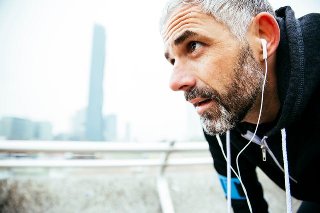 Austria, Vienna, exhausted athlete wearing earphones