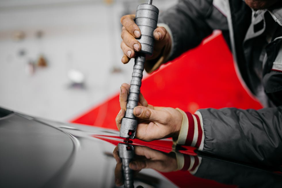 auto body mechanic disassembling damaged vehicle