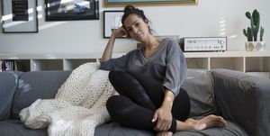Portrait confident Latina woman relaxing on living room sofa
