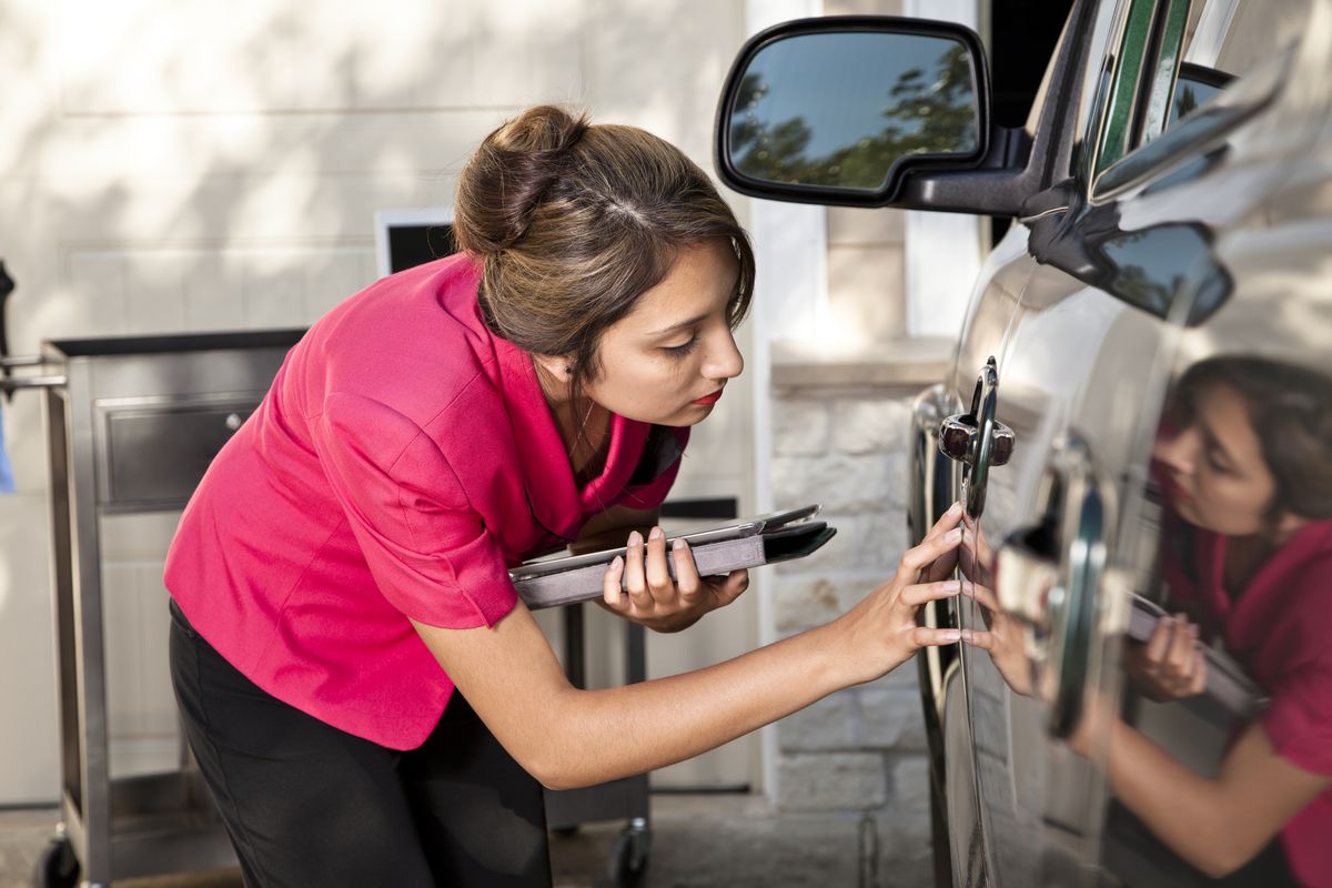 automobile insurance adjuster inspecting damage to vehicle