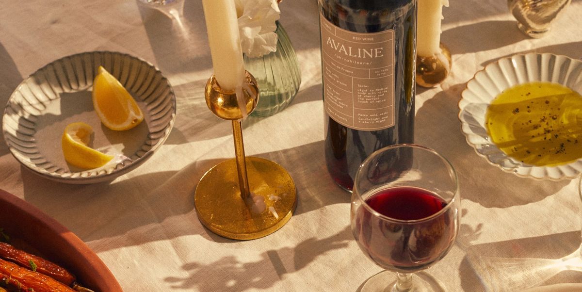 avaline red wine on table with candles, lemons, olive oil