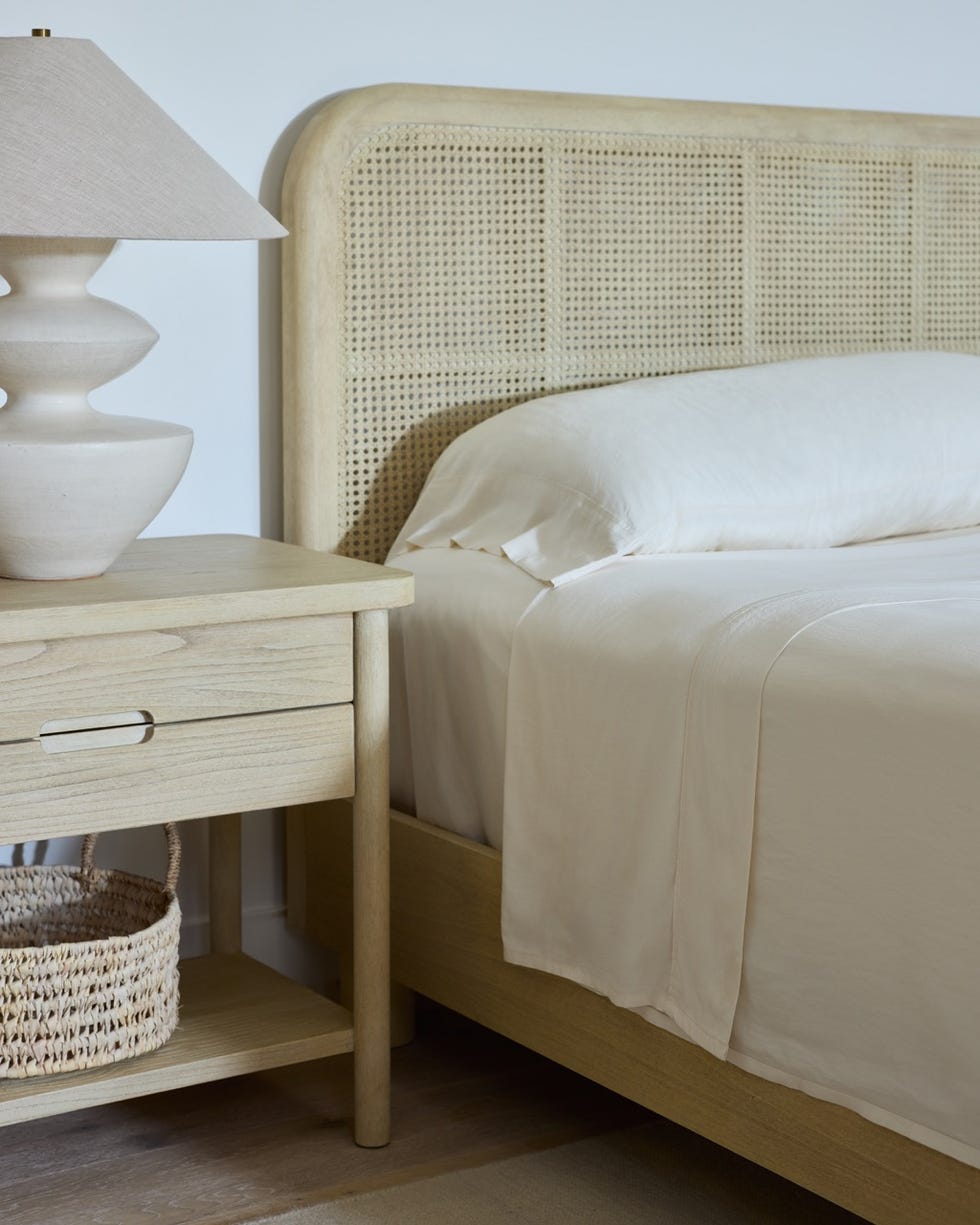 neutraltoned bedroom corner featuring a bed nightstand lamp and woven basket