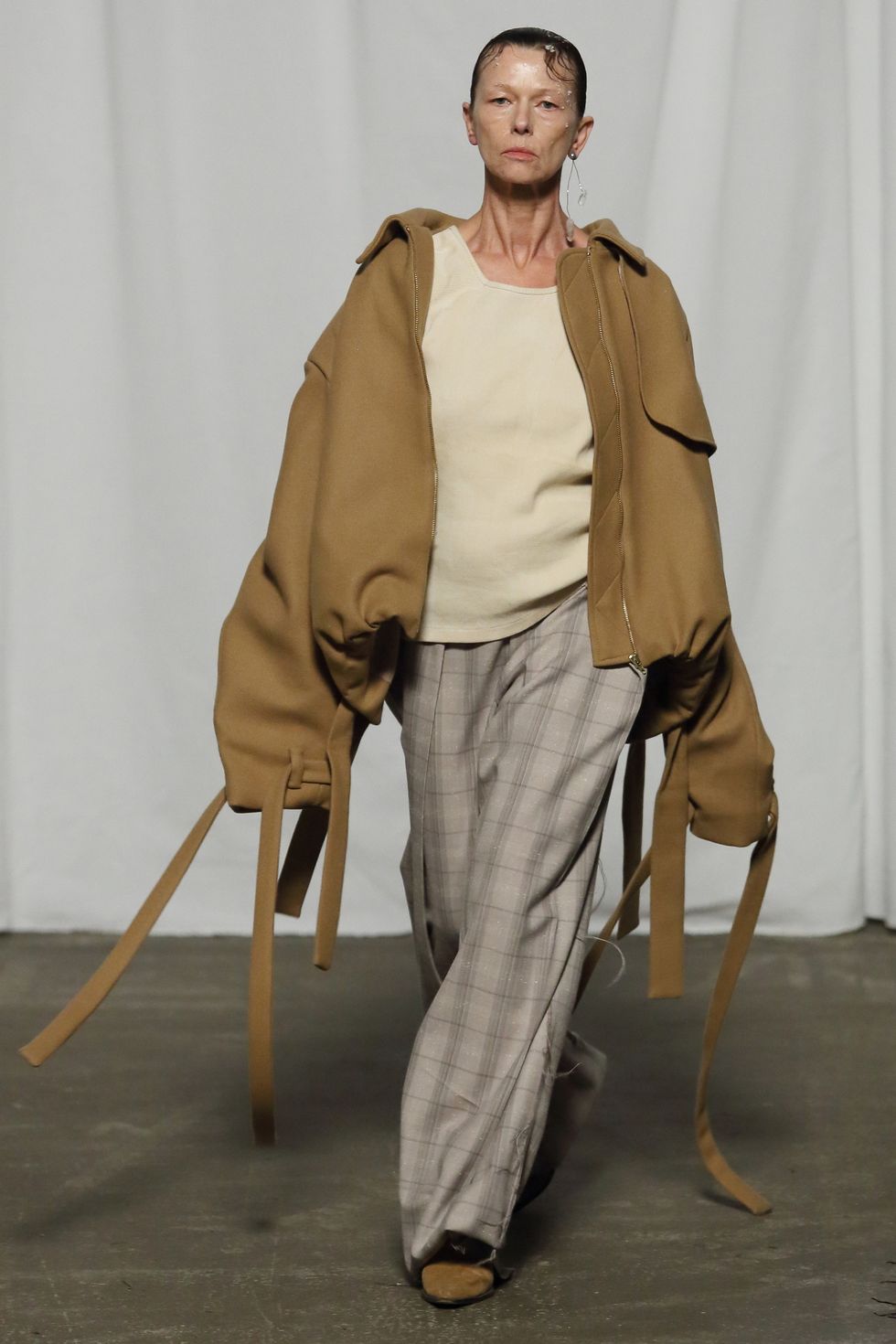 a person wearing a brown jacket and holding a cane