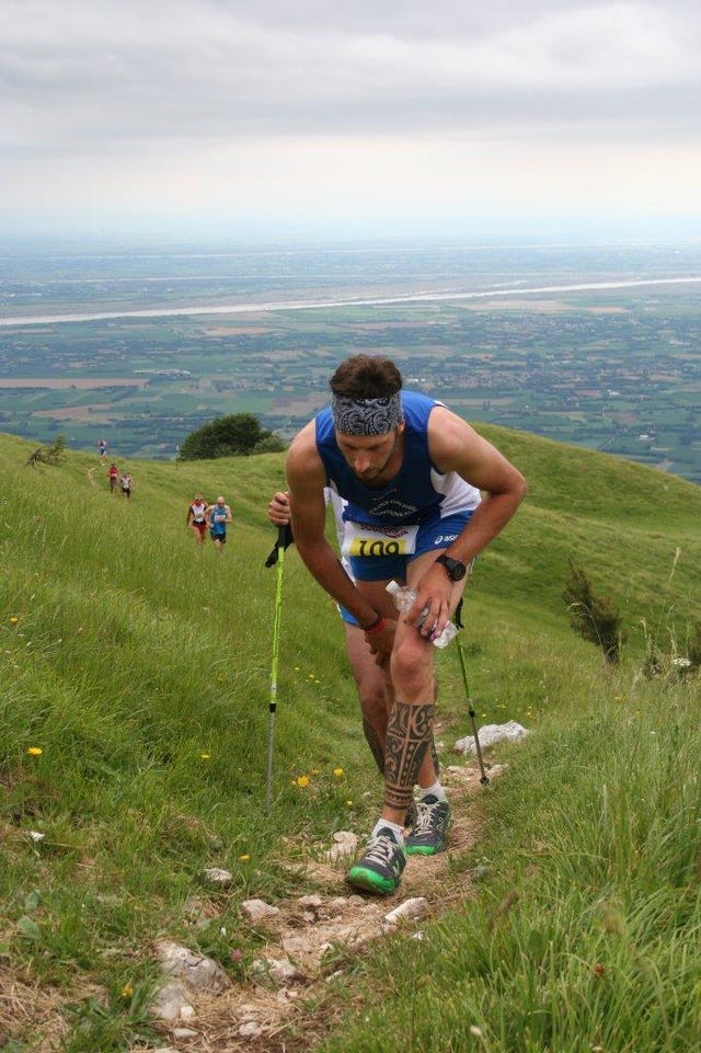 runner participating in a trail race on a grassy slope