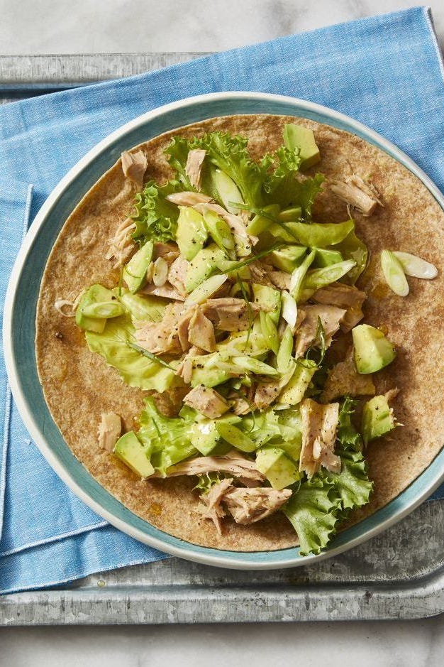 avocado and tuna salad wrap with a blue napkin