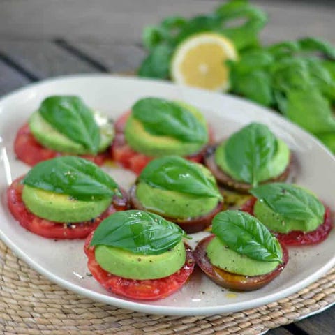 tomato, avocado, and basil on a white dish