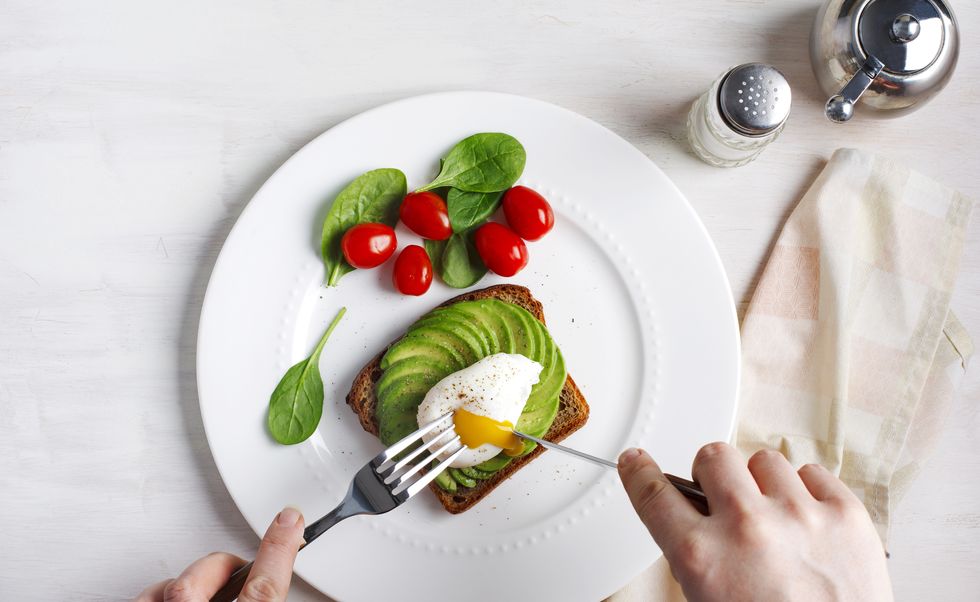 Avocado Sandwich with Poached Egg. Sliced avocado and egg on toasted bread for healthy breakfast
