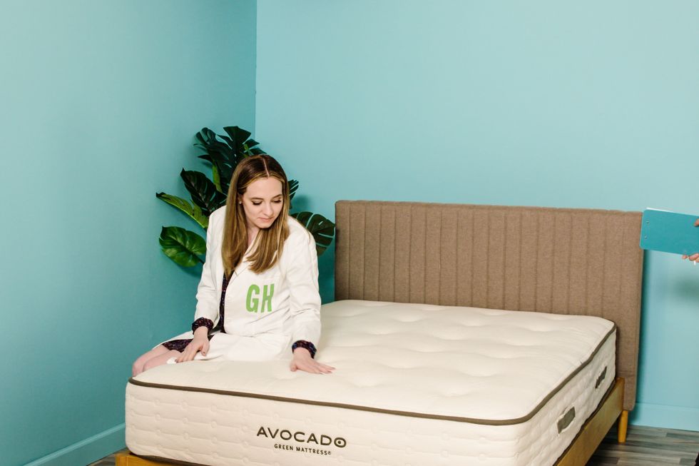 an analyst sits on the edge of the avocado green mattress