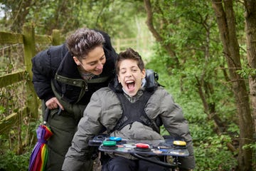 sarah webber and her son george walking through the wood using his power wheelchair supplied by whizz kidz