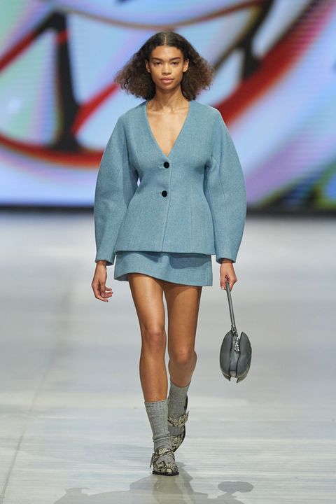 a model walks the ganni runway wearing a ganni suit