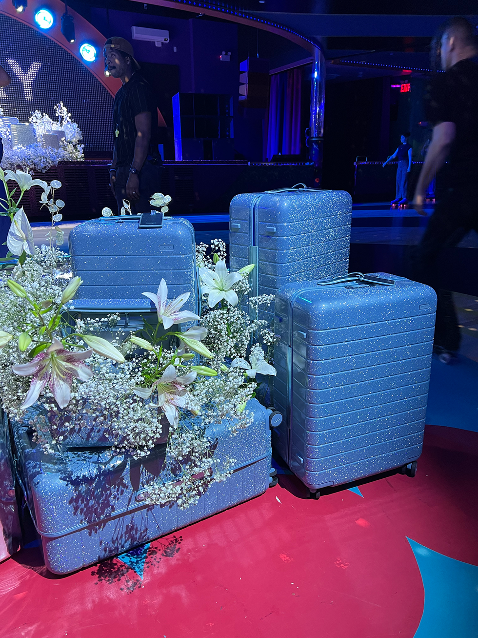 multiple bright blue suitcases adorned with flowers