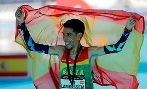 ayad lamdassem celebra envuelto en la bandera de españa el récord de españa de maratón logrado en valencia