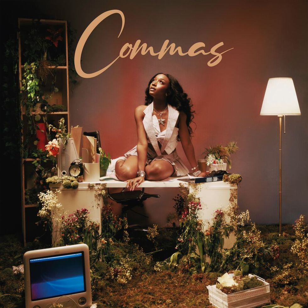 ayra starr album cover sitting on a table wearing a cream outfit and surrounded by flowers