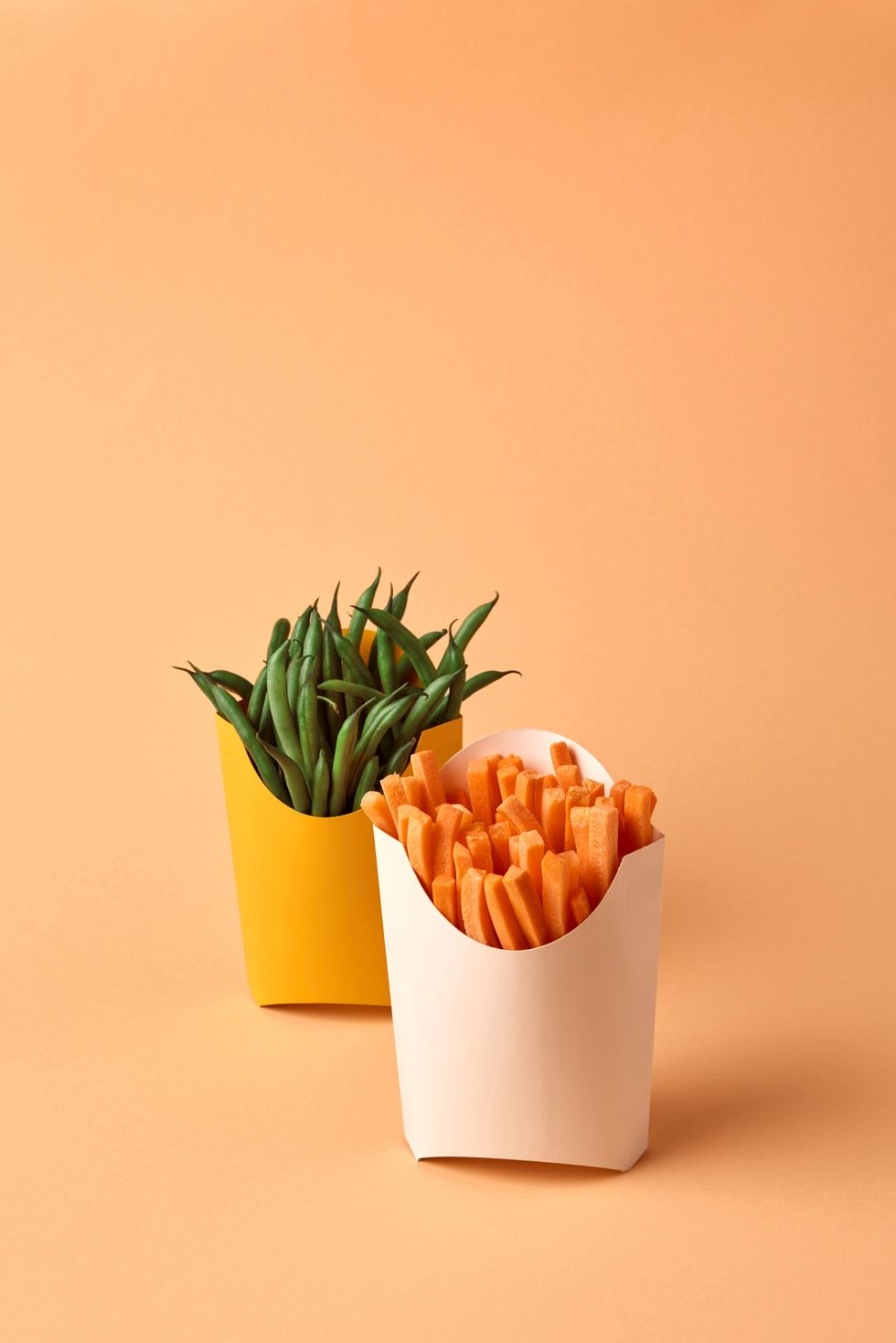 fresly picked natural organic vegetables french beans and carrots sticks in a paper cups on a paper background healthy right snack for schoolboy place for text