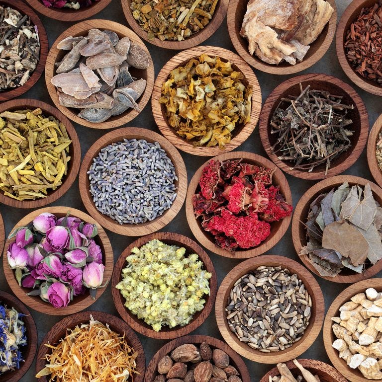 natural herbal medicine selection with a variety of dried herbs and flowers in wooden bowls top view