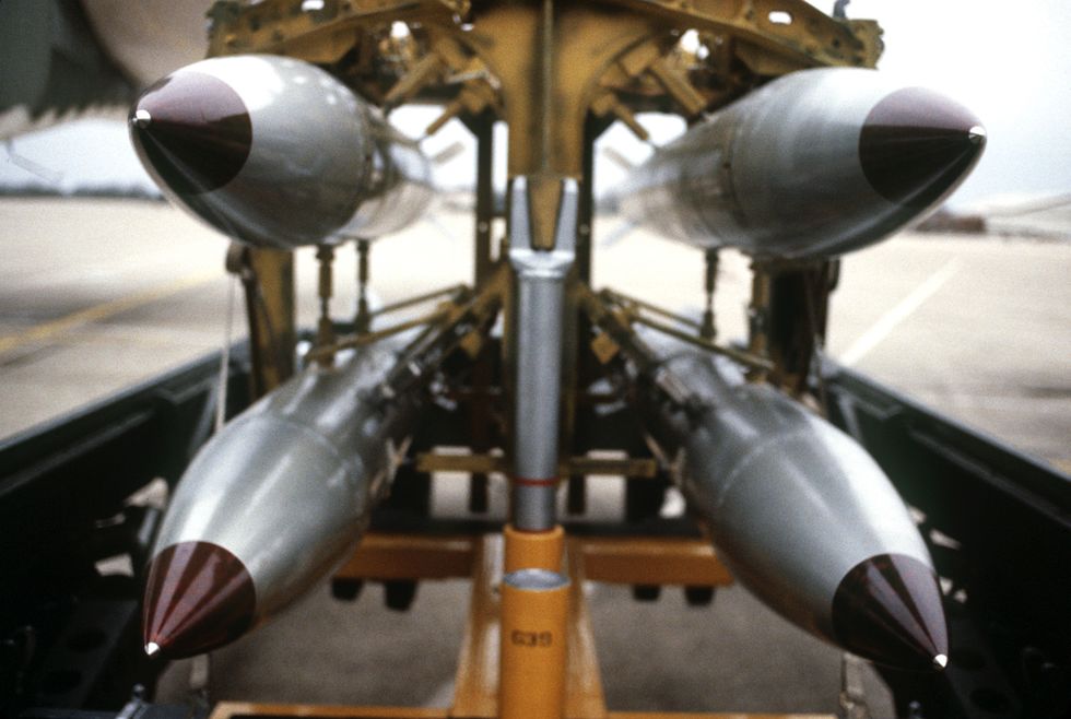 a front view of four nuclear free fall bombs on a bomb cart