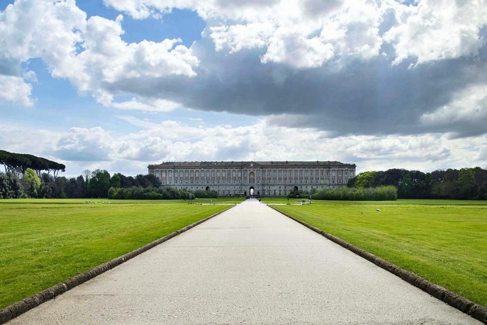 gardens leading to a grand building under a cloudy sky