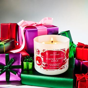 a scented candle surrounded by festive gift boxes a scented candle surrounded by festive gift boxes