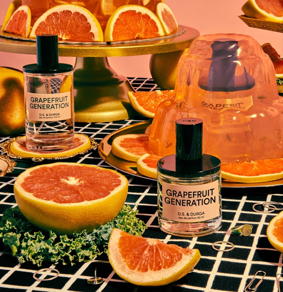 bottles of grapefruitscented perfume surrounded by sliced grapefruits and decorative elements